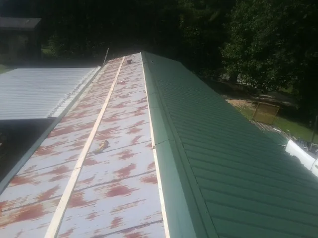 Old rusted panels beside newly installed green metal roofing — Wind Damage Roof Repair by Roofing Brothers in Lodi